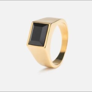 Gold tone ring with black gem